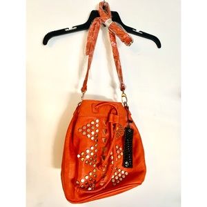 Reddish orange bucket bag with gold hardware
